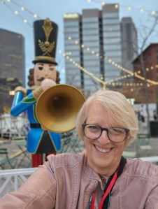 Woman with life size nutcracker with trumpet