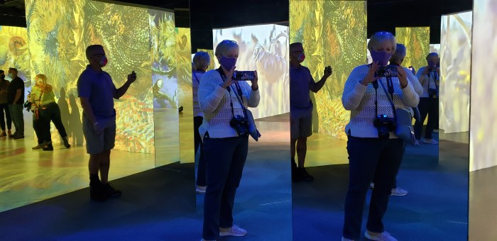 Man and woman taking photos reflected in mirros