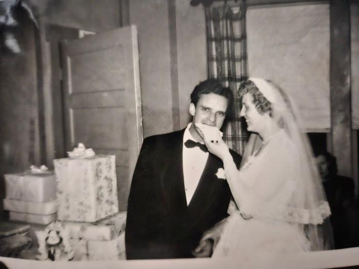 1950s man and women sharing a piece of wedding cake