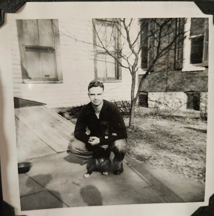1950s man holding black puppy
