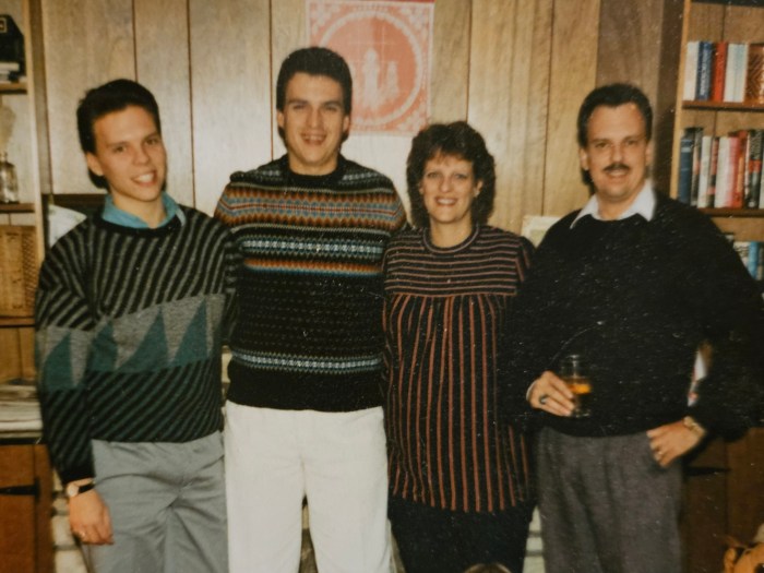 Three men and one woman standing together